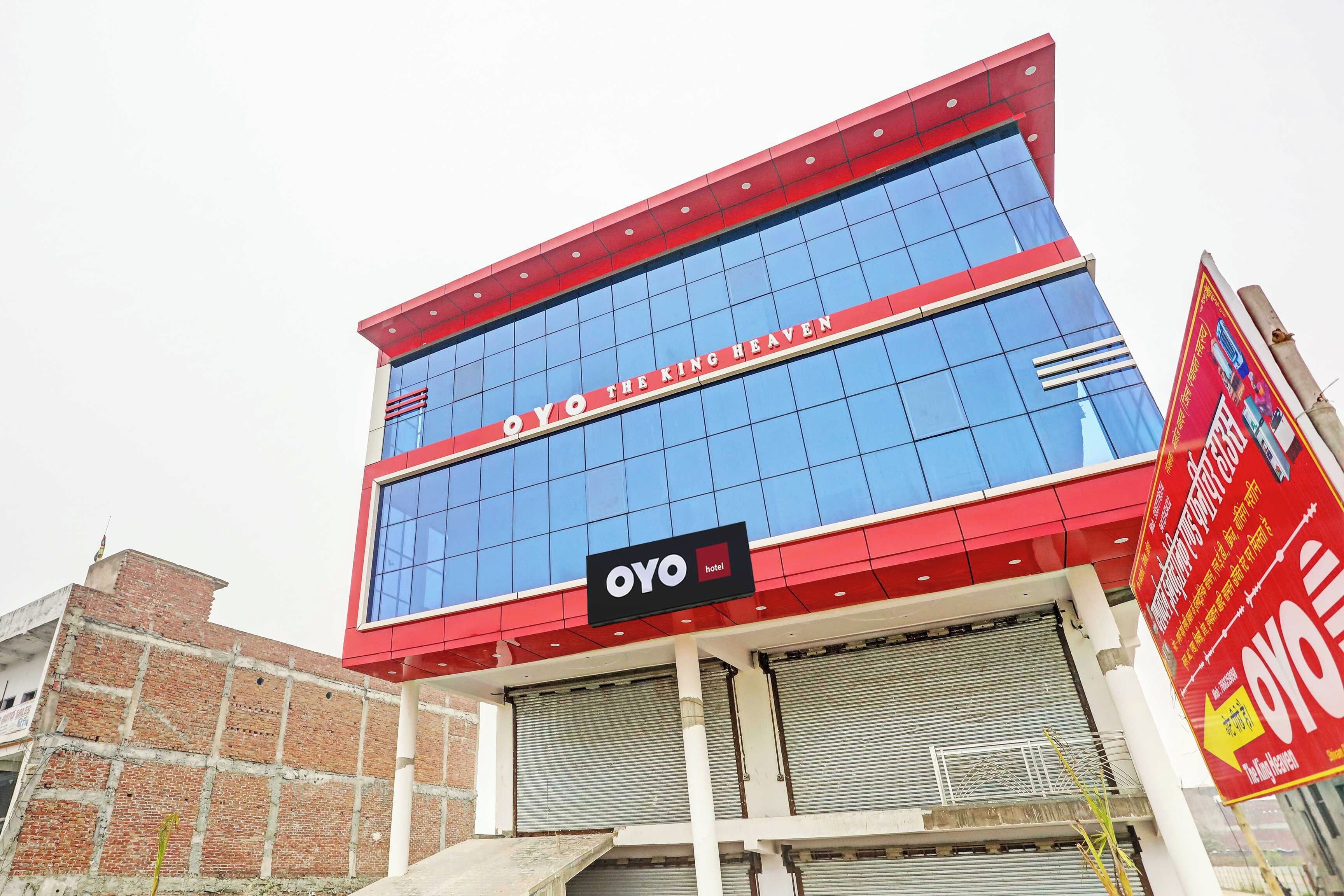 Een hotelgebouw met een opvallend bord waarop 'OYO THE KING HEAVEN' staat.