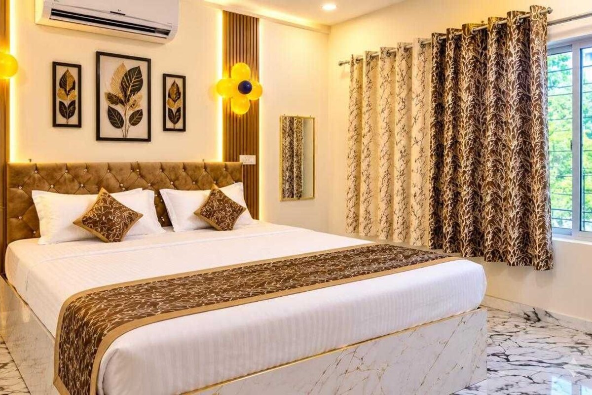 A bedroom with a large bed, a potted plant, and decorative wall art.