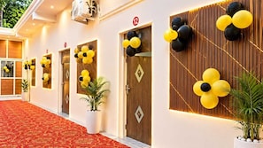 A hotel corridor with doors numbered 11 to 12, decorated with yellow and black balloons. - Hotel O Mahi Palace (Bisalpur)