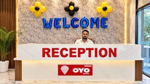 A reception desk with a 'WELCOME' sign above and a 'RECEPTION' sign below. There is a logo for 'OYO ROOMS' on the desk. - Hotel O Mahi Palace (Bisalpur)