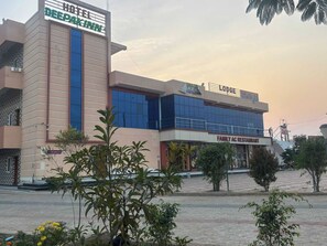 A hotel with a sign for 'HOTEL DEEPAKINN' and a 'FAMILY AC RESTAURANT' on the ground floor.