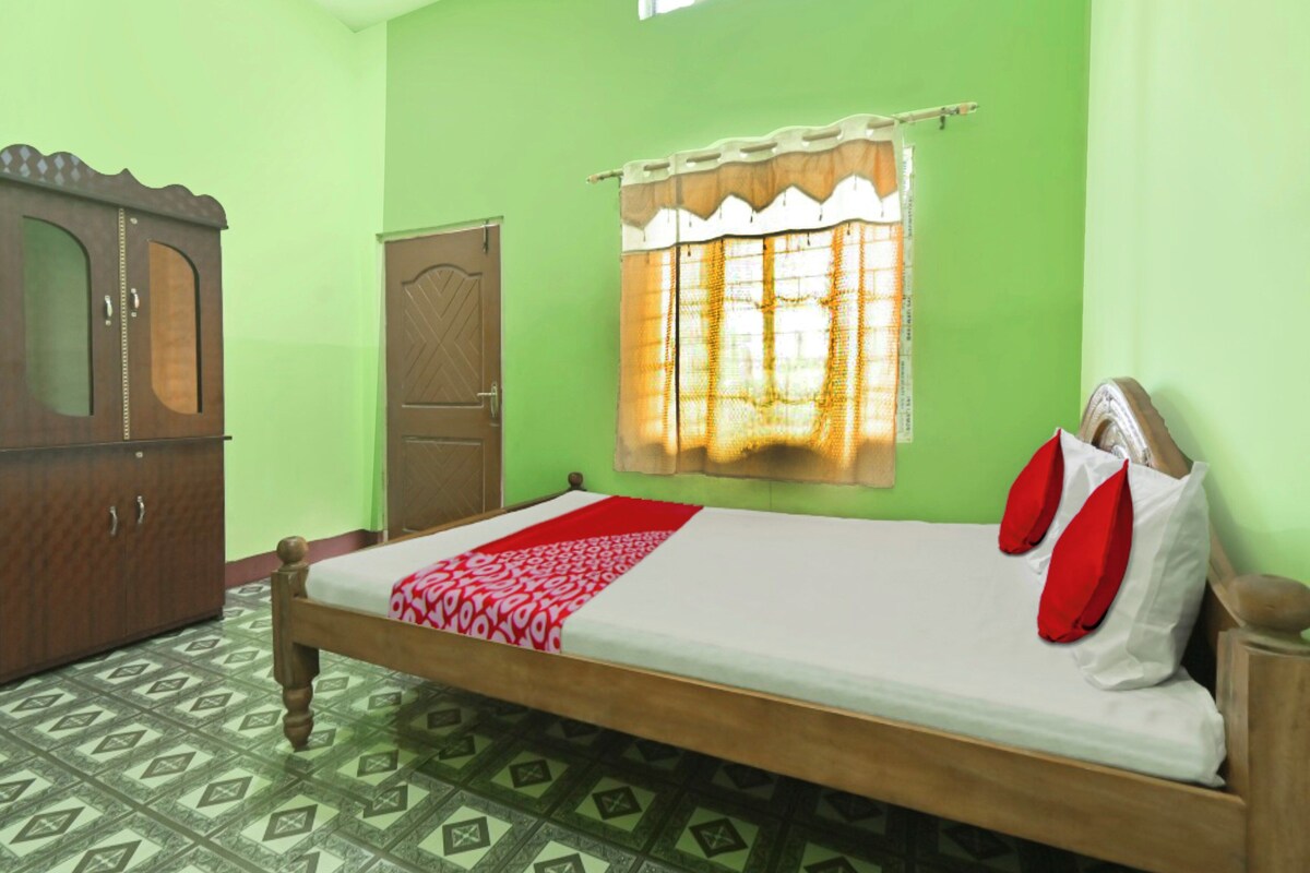 A room with a bed, a wardrobe, and a window with curtains.