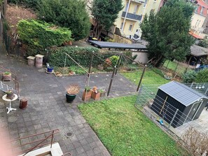 A courtyard with a fenced area, potted plants, a small shed, and a building in the background. - Top location • Family-friendly • Parking • Netflix (Ludwigshafen am Rhein)