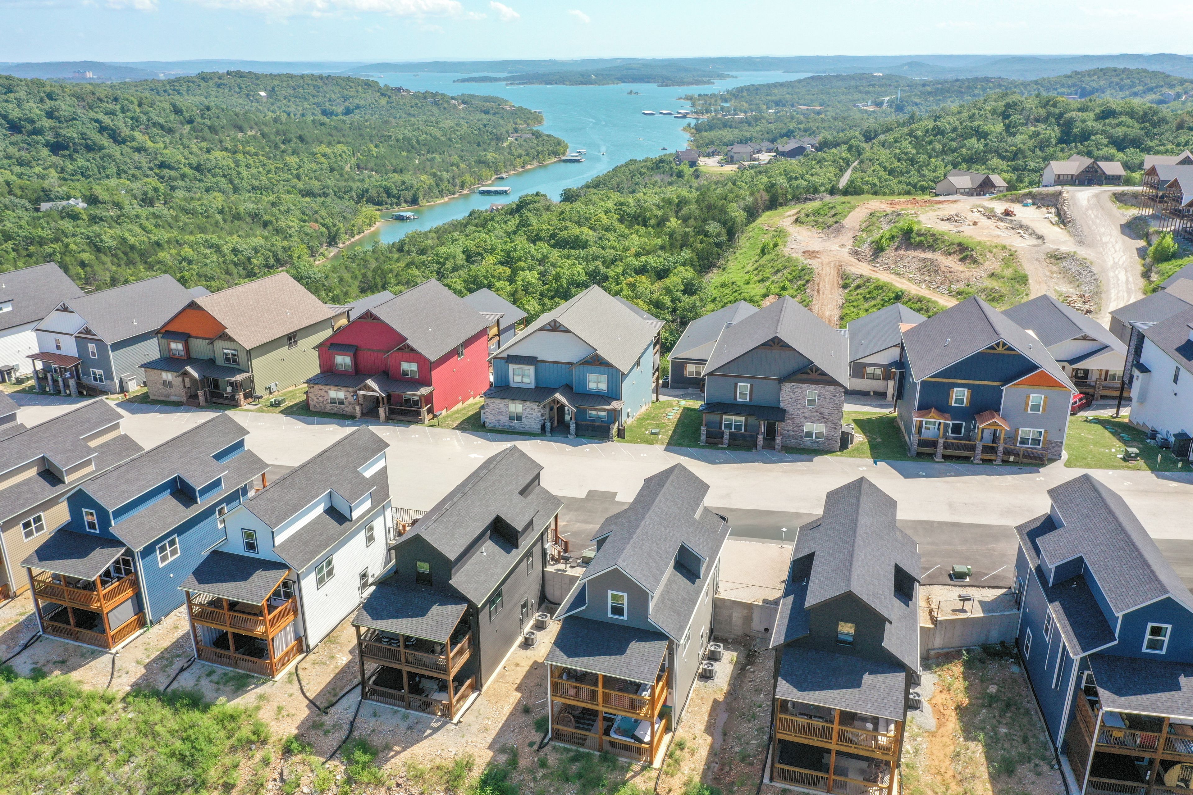 Un quartier résidentiel avec des maisons et un lac en arrière-plan.