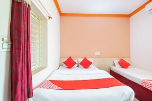 A hotel room with two single beds, a window with a curtain, and a wall with a light peach color. - Hotel O Sri Sai Samrat Lodge (Bangalore)