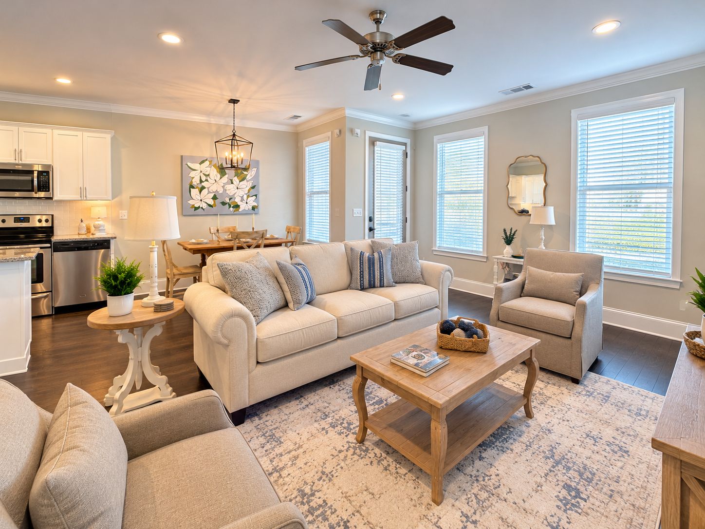 A living room with a sofa, armchairs, a coffee table, and a dining area with a table and chairs.