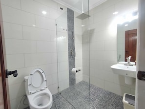 A bathroom with a toilet, a shower, and a sink. - Collection O Four Petals Inn (Dumangas)
