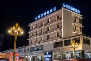 A multi-story hotel with illuminated signage and a prominent entrance. - Ruyi Meiju Hotel (Lijiang Dashuiche) (Lijiang)