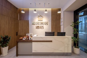 A hotel reception desk with a modern design, featuring a marble countertop, wooden paneling, and pendant lighting. - Ruyi Meiju Hotel (Lijiang Dashuiche) (Lijiang)