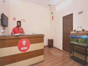 Una reception con il logo 'OYO', un orologio e un acquario.