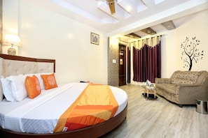 Una camera d'albergo con un letto, un divano, una lampada e un quadro appeso al muro.
