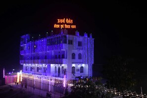 Un edificio de varios pisos, rodeado de luces colgantes.