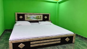 A bed in a room with green walls and a painting above it. - Hotel O The Sky Hotel (Chhibramau)