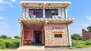 A two-story building with a sign advertising 'The Sky Hotel Oyo' offering 24x7 AC & Non AC rooms. - Hotel O The Sky Hotel (Chhibramau)
