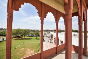 A view from a balcony with a traditional architectural style, featuring arches and columns.