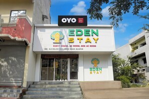 A hotel named Eden Stay with a sign indicating it offers guest houses, AC rooms, and non-AC rooms. - Hotel O Eden Stay (Bilaspur)