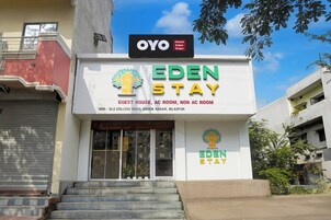 Um hotel chamado Eden Stay com uma placa indicando que oferece casas de hóspedes, quartos com ar condicionado e quartos sem ar condicionado.