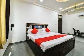 A hotel room with a bed, a desk, and a chair. - Hotel O Apple Inn (Bharatpur)