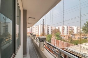 Un balcon donnant sur un quartier résidentiel et un chantier de construction.