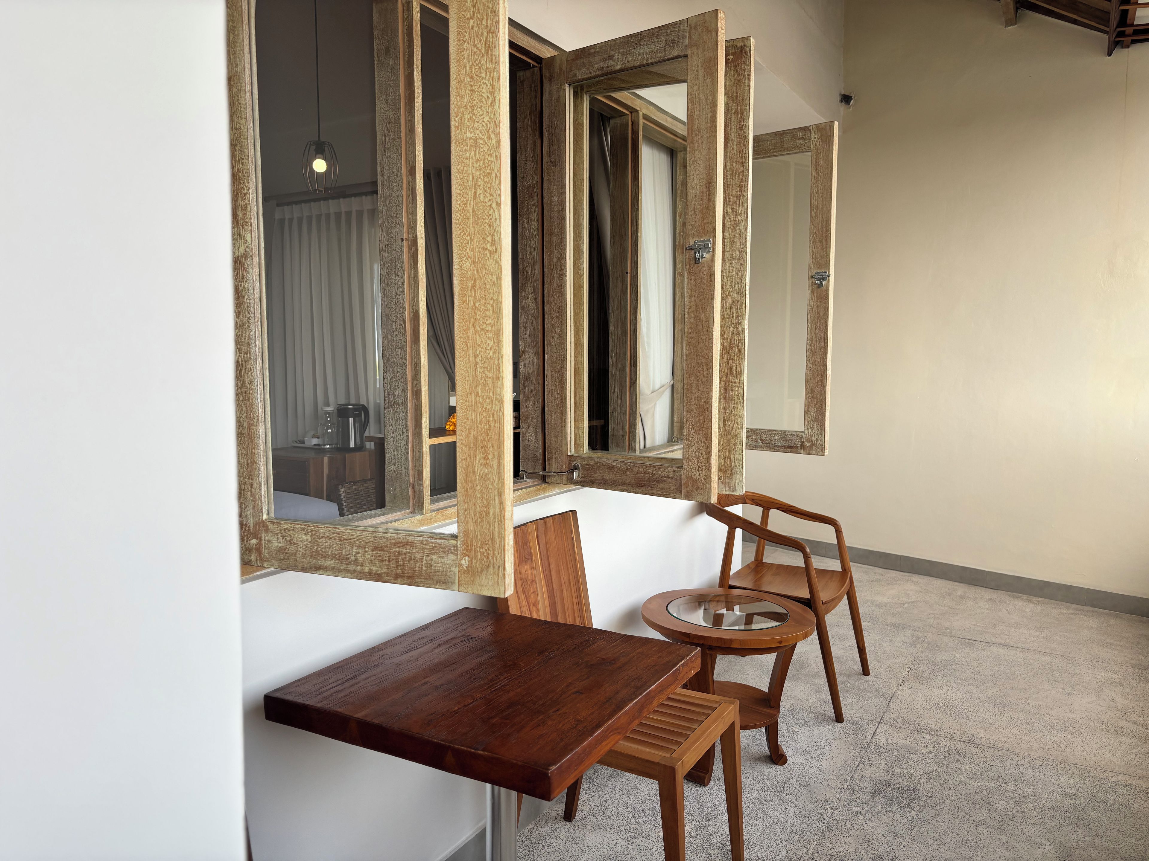 A room with a wooden bench, a small round table, and two chairs.
