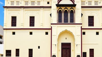 Un edificio con entrada central, varias ventanas y detalles decorativos.