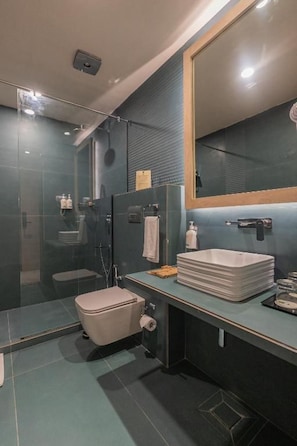 A modern bathroom with a glass shower enclosure, a toilet, and a sink with a mirror above it. - Resort De Coracao Tapovan Rishikesh (RISHIKESH)