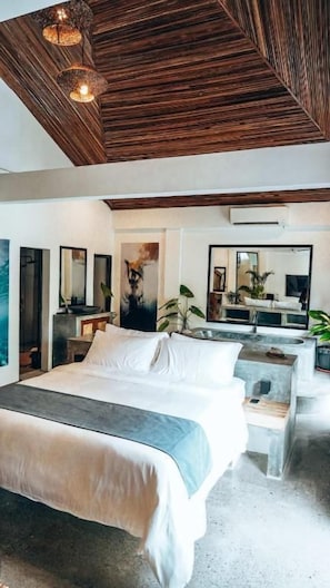 A modern bedroom with a large bed, a desk, and a mirror. - Bliss villa by Happiness Philippines (El Nido)