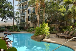 A pool area with lounge chairs, a rock feature, and a multi-story building with balconies. - Westin Kaanapali Ocean Resort Villas North - Oceanfront 2 bed/2 bath Sleeps 8 (Lahaina)