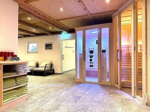 Eine Hotelhalle mit einer Rezeption, einer Sitzecke mit einer Couch und einer Holzbalkendecke.
