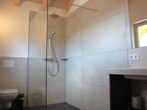 Ein modernes Badezimmer mit einer Duschkabine, einer Toilette und einem Waschbecken.