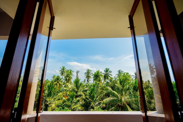 A balcony with a view of palm trees and a clear sky.
