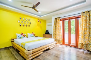 A room with a bed, a ceiling fan, a wall-mounted air conditioner, and a window with curtains. - Hotel O Signature Grande (Pondicherry)