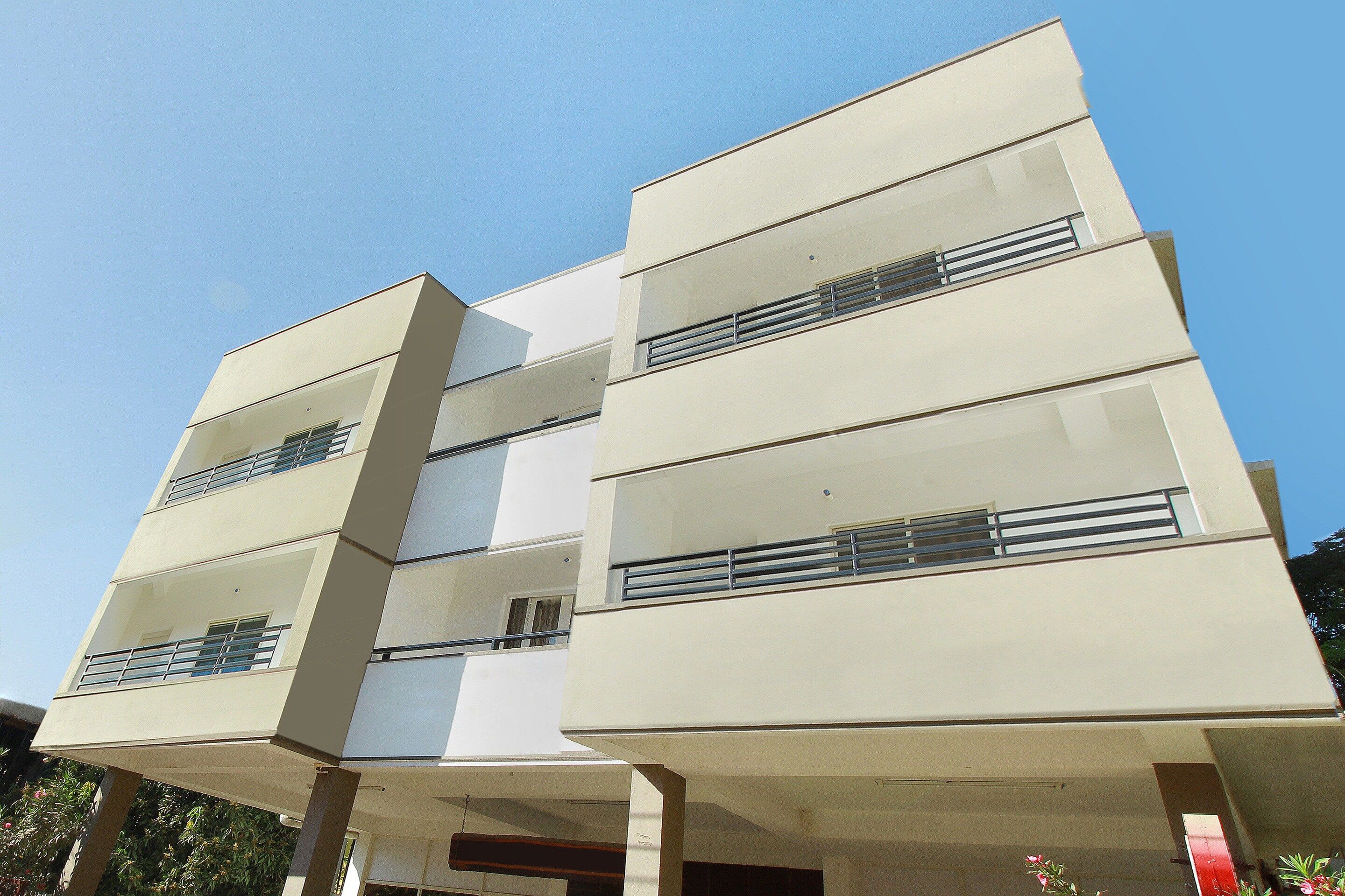 A multi-story building with a flat roof and large windows.