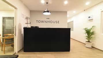 A reception desk with a sign reading 'TOWNHOUSE' and a potted plant to the right.