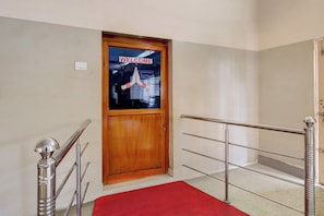 A wooden door with a 'WELCOME' sign, a red carpet, and metal handrails. - Hotel O Ramachandra Hospital Porur (Chennai)