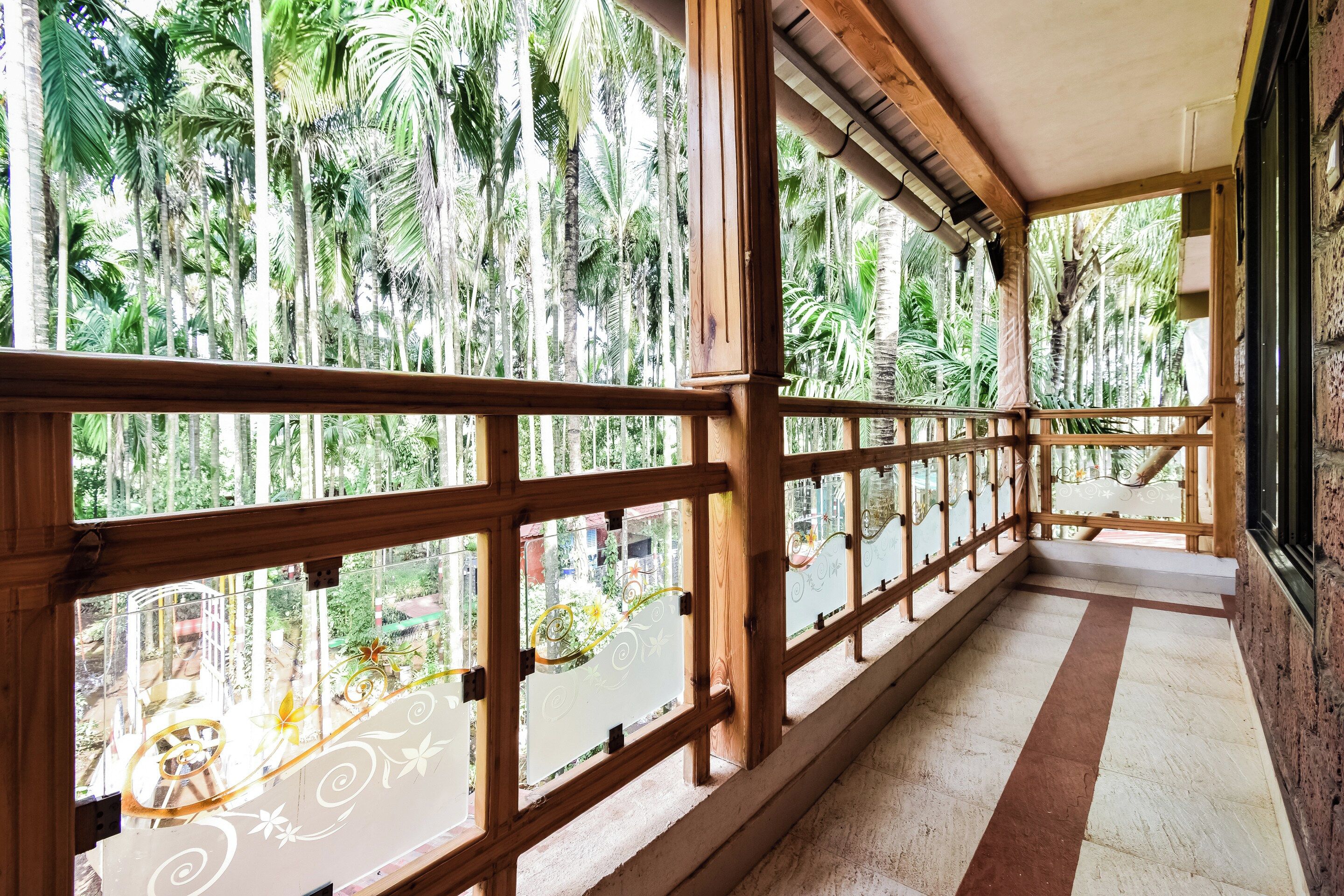 A wooden balcony with a view of a tropical garden.