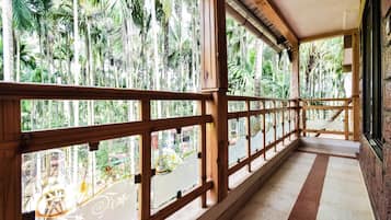 Un balcón de madera con vistas a un jardín tropical.