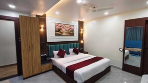 Una habitación de hotel moderna con una cama grande, una pared decorativa de madera, un cuadro sobre la cama y un ventilador de techo.