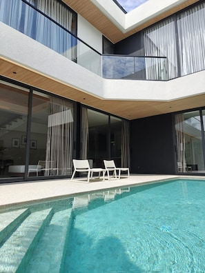 A modern two-story house with a swimming pool, large windows, and outdoor seating. - Villa Paora Aileen Villas by Tropiclook (Choeng Thale)