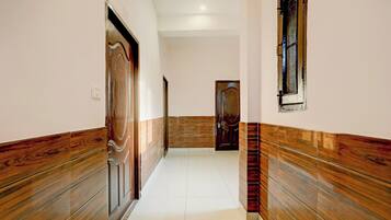 A hallway with wooden paneling on the walls and a tiled floor.