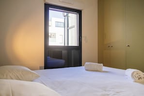 Une chambre d’hôtel avec un lit, une fenêtre et une armoire.