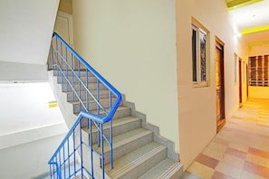 Un escalier avec des rampes bleues menant à l’étage supérieur.