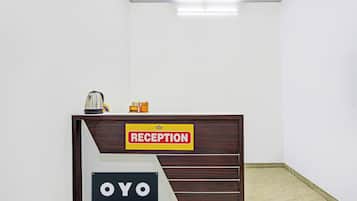 A reception desk with a 'RECEPTION' sign, a coffee machine, and a small toy train.