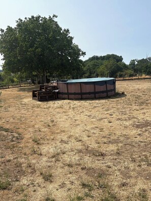 A fenced area with a covered structure, possibly a tent or a small building, and a wooden bench.