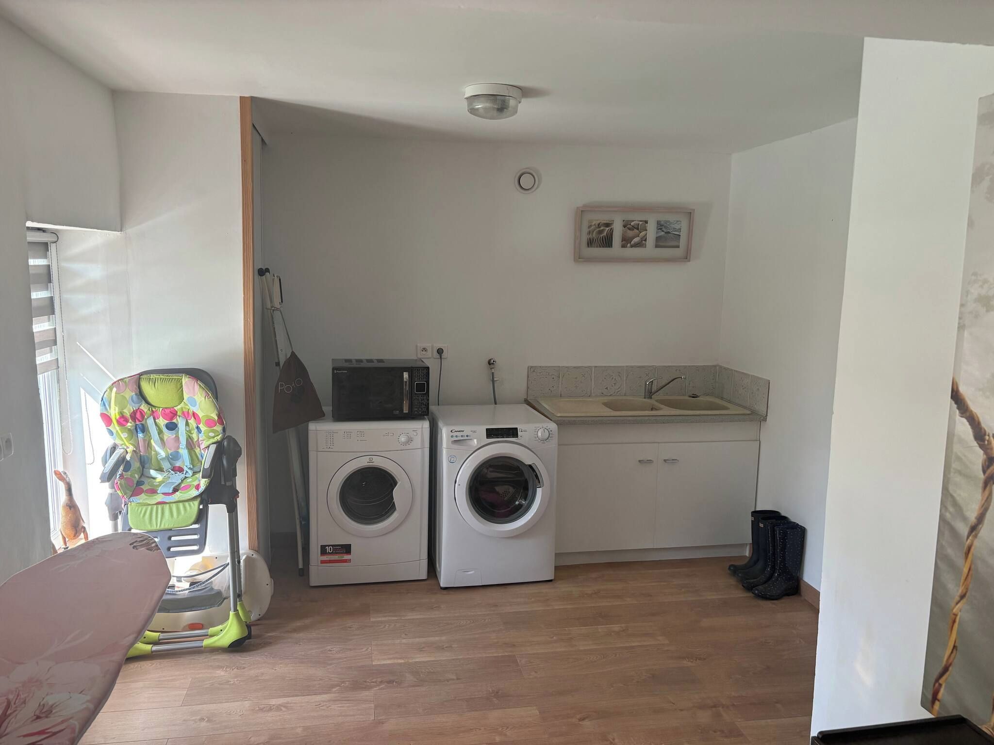 A compact kitchen with a washing machine, a microwave, and a sink.