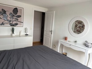 A bedroom with a bed, a dresser, a mirror, and a painting on the wall. - 4 guests with beautiful views (Saint-Agnant-de-Versillat)