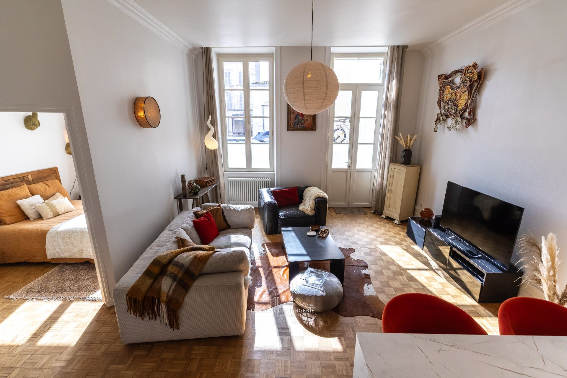 Ein helles Wohnzimmer mit einer Couch, einem Couchtisch, einem Fernseher und einem Kamin.