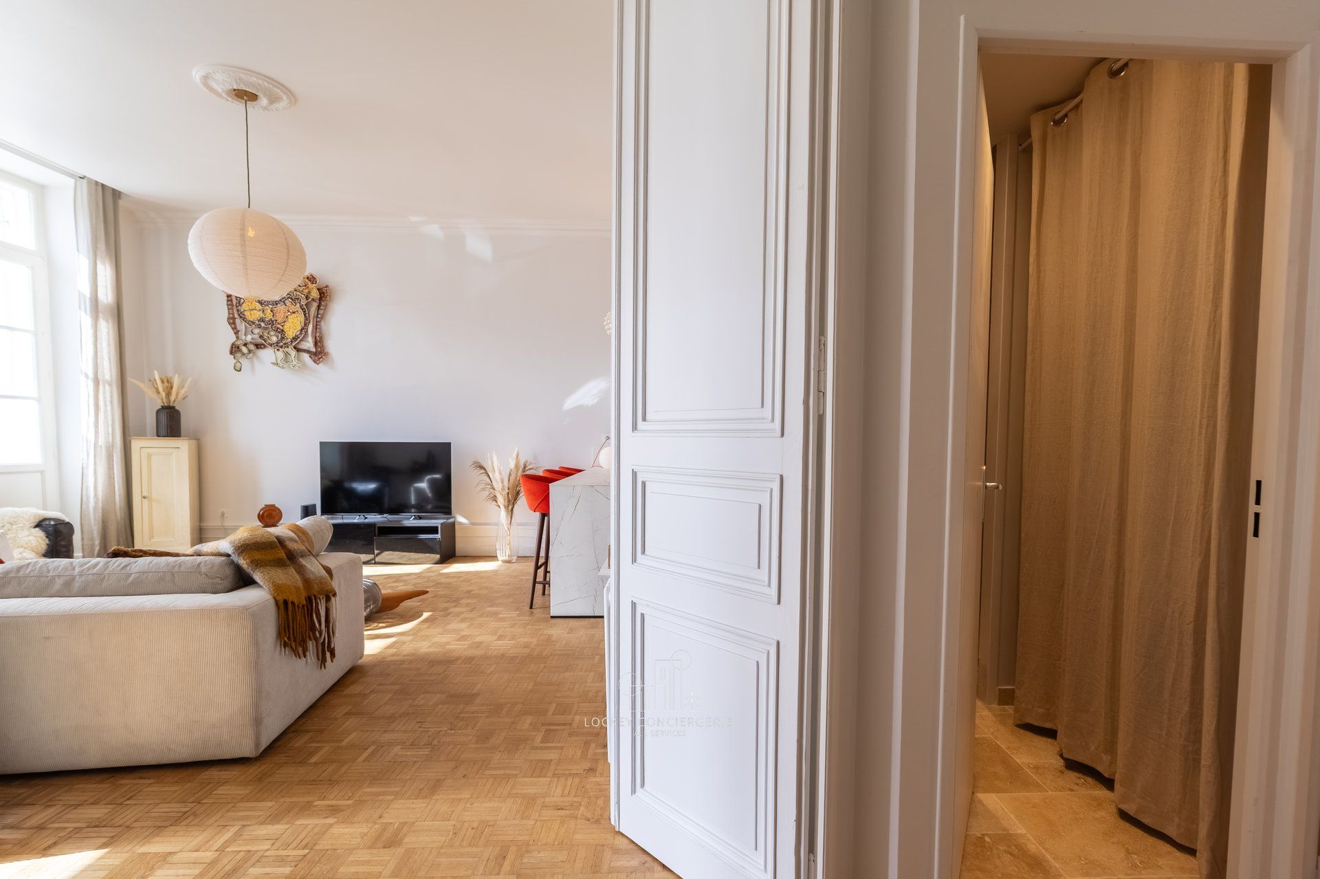 Ein modernes Wohnzimmer mit einer Couch, einem Fernseher und Dekoelementen.