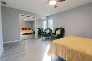 A bedroom with a bed, two chairs, a ceiling fan, and a sliding door leading to another room. - 2 Mi to Campus! Convenient Townhome in Normal (Normal)