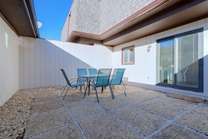 A patio with a table and chairs, a gravel ground, and a building with a window and a door. - 2 Mi to Campus! Convenient Townhome in Normal (Normal)